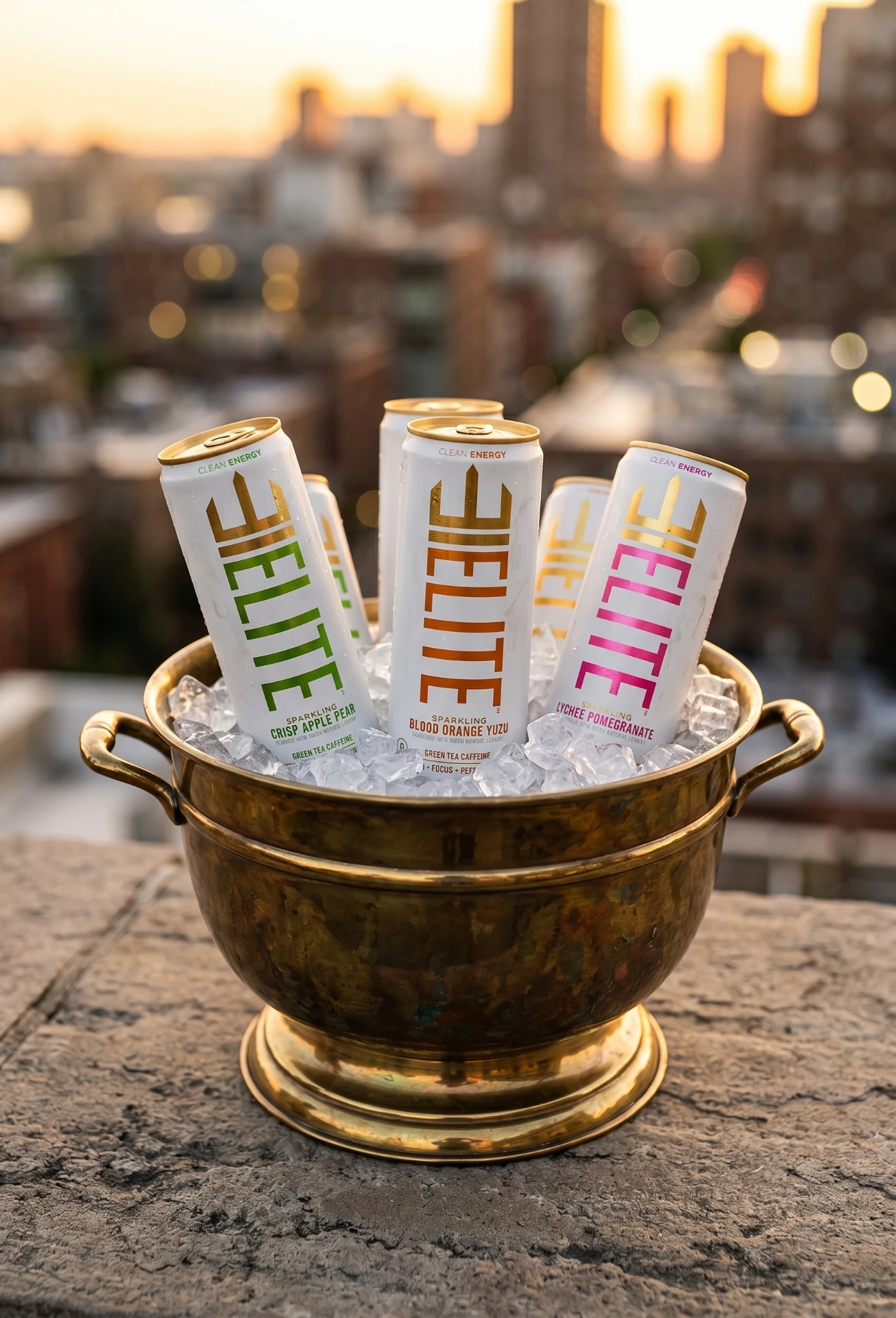 ELITE cans chilling in a brass ice bucket on a rooftop at sunset